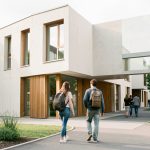 Quels critères choisir pour investir en résidence étudiante en 2026 après Censi-Bouvard ? Résidence étudiante contemporaine près d’un campus français, avec une jeune femme et un jeune homme portant des sacs à dos devant une façade sobre, éclairée par la lumière naturelle.
