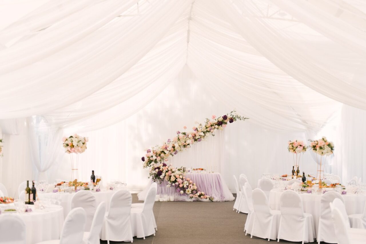 Tente de mariage aménagée avec des tables, des chaises et une décoration élégante pour la réception.